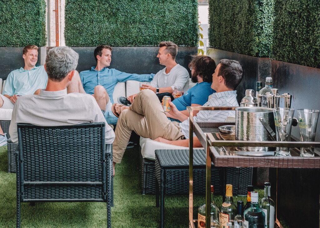 family hanging out on outdoor patio with drinks, conversation, bar